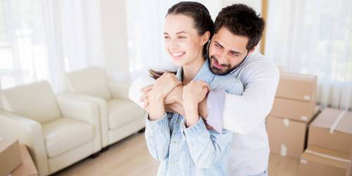 Couple souriant venant d'emménager dans leur nouvelle maison