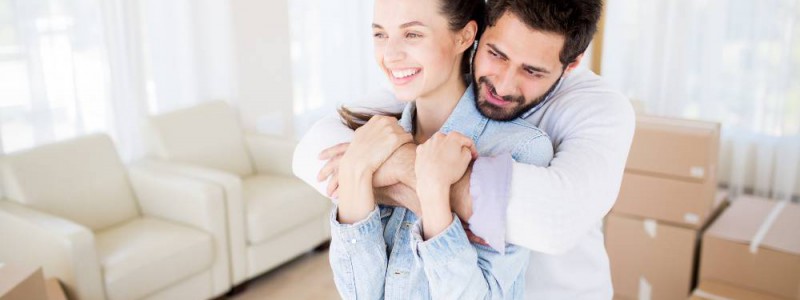 Couple souriant venant d'emménager dans leur nouvelle maison