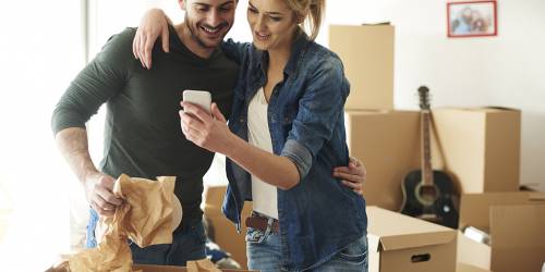 couple qui emménage ensemble avec leurs cartons en arrière plan