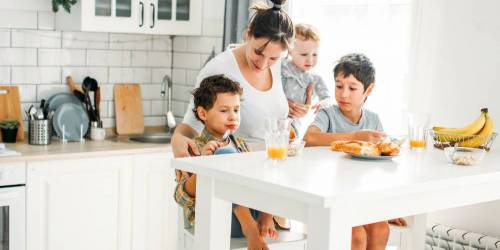 Mère et ses trois enfants prenant le petit déjeuner