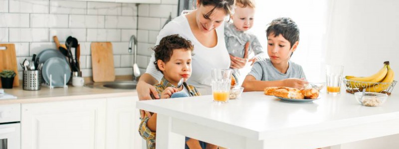 Mère et ses trois enfants prenant le petit déjeuner