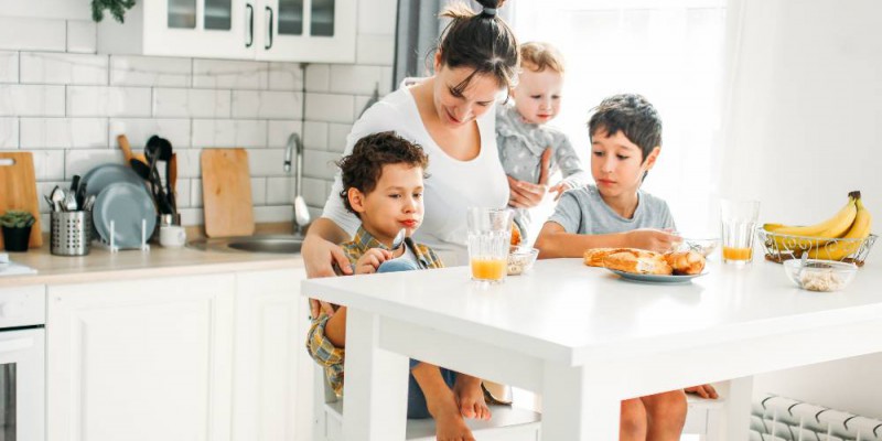 Mère et ses trois enfants prenant le petit déjeuner