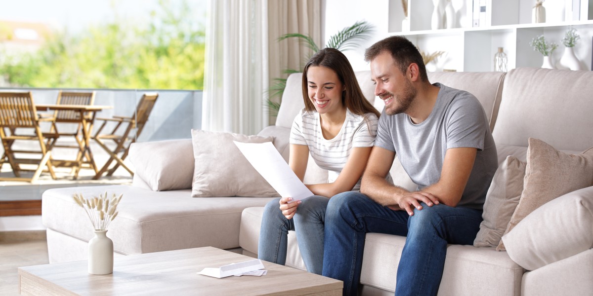 Un jeune couple de locataires souriant dans leur salon lors de la signature d'un rachat de crédit pour optimiser leur budget.