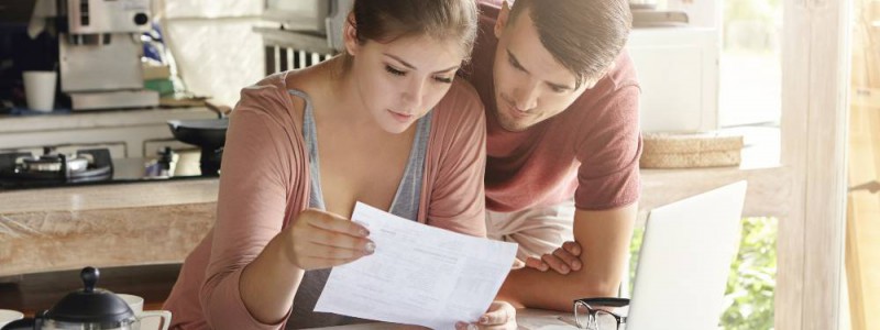 couple faisant le calcul de sa capacité d'emprunt sur un ordinateur portable dans la cuisine