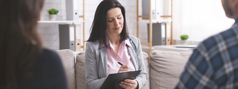 Conseillère financière prenant des notes en présence d'un couple de futurs emprunteurs