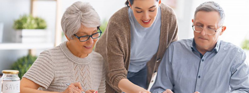 Parents âgés et leur fille, membres d'une SCI familiale, faisant une simultion de rachat de cérdits.