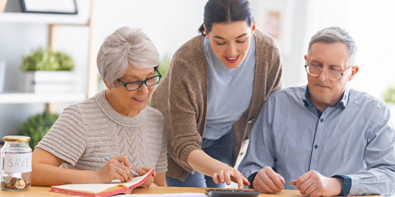 Parents âgés et leur fille, membres d'une SCI familiale, faisant une simultion de rachat de cérdits.
