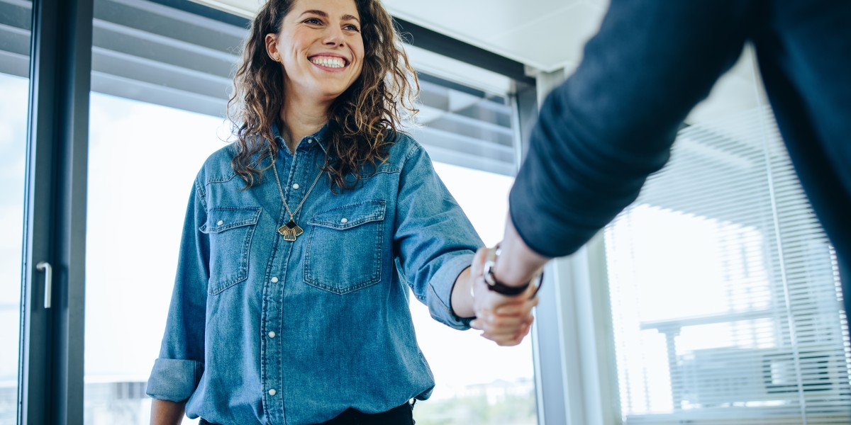 Femme qui serre la main à une autre personne pendant un entretien