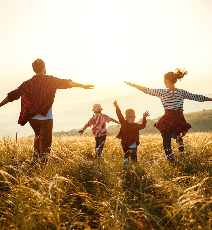 Famille courant vers le soleil couchant